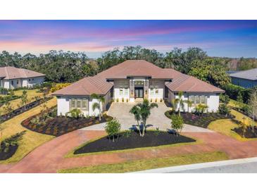 Luxury home with tile roof, expansive driveway, and lush landscaping at 3927 Founders Club Dr, Sarasota, FL 34240