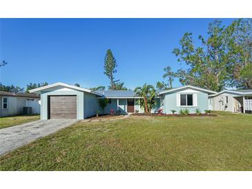 Charming single-story home with a well-manicured lawn, blue paint, and a detached garage at 3952 Coleridge Pl, Sarasota, FL 34241