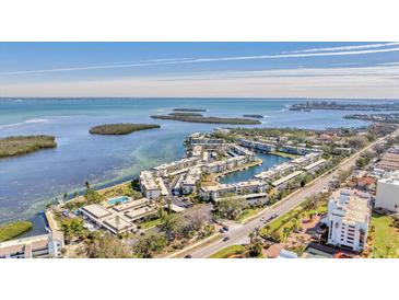 Aerial view of waterfront community with boat slips and lush landscaping at 4350 Chatham Dr # E106, Longboat Key, FL 34228