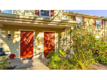 Front view of two-story townhouses with red doors and lush landscaping at 4850 51St W St # 9106, Bradenton, FL 34210