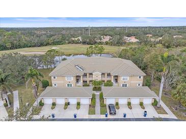 Aerial view of condo community showcasing building, landscaping, and golf course views at 6334 Grand Oak Cir # 201, Bradenton, FL 34203