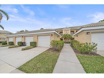 Exterior view of condo building showcasing garages and landscaped grounds at 6334 Grand Oak Cir # 201, Bradenton, FL 34203