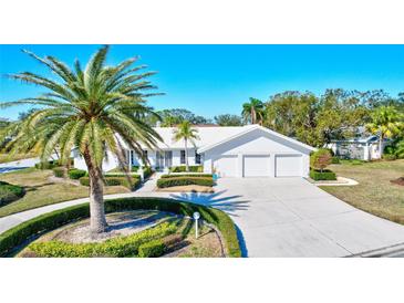 White two-story house with a three-car garage and palm trees at 6851 Country Lakes Cir, Sarasota, FL 34243