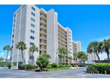 Exterior view of a multi-story building with lush landscaping at 9393 Midnight Pass Rd # 302, Sarasota, FL 34242