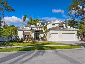 Beautiful two-story home featuring manicured lawn, mature palm trees, and a three-car garage at 1519 Harbor Dr, Sarasota, FL 34239