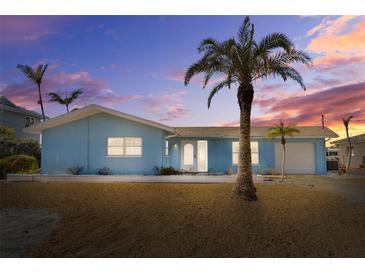 Charming light blue house with palm trees, and a well-maintained lawn at 2762 W Vina Del Mar Blvd, St Pete Beach, FL 33706