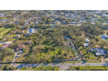 Large lot in a residential area, marked with a white border, surrounded by lush trees and greenery at 3864 Gocio Rd, Sarasota, FL 34235