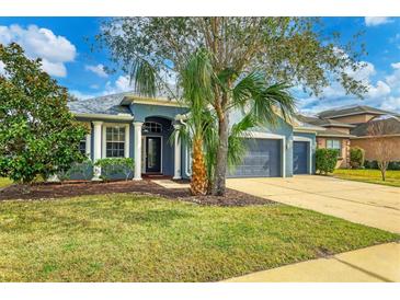 Single-story home with gray exterior, landscaping, and a two-car garage at 4360 85Th Avenue E Cir, Parrish, FL 34219