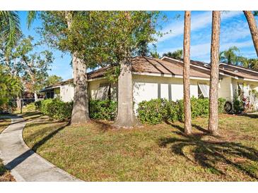 Exterior view of a light-colored house with mature trees and landscaping at 5348 Royal Palm Ave # 5348, Sarasota, FL 34234