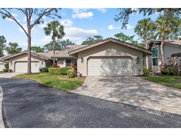 Tan-colored villa with attached garage and landscaped front yard at 5655 Pipers Waite # 27, Sarasota, FL 34235