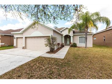 Charming single-story home featuring a well-manicured lawn and attached two-car garage at 11715 Summer Springs Dr, Riverview, FL 33579