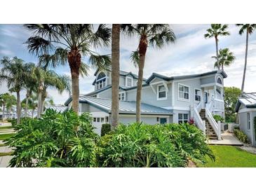 Two-story home with gray siding, metal roof, and lush landscaping at 1228 Siesta Bayside Dr # 1228-C, Sarasota, FL 34242