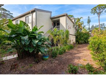 Exterior view of condo with lush landscaping and walkway at 1512 Pelican Cove Rd # 239, Sarasota, FL 34231