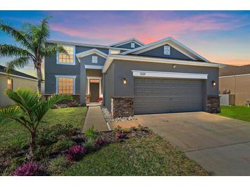 Two-story house with gray siding, stone accents, and a two-car garage at 509 Powder View Dr, Ruskin, FL 33570