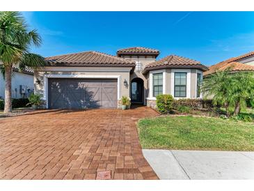 One-story home with brown tile roof, gray garage door, and landscaped yard at 5406 Morey Farms Loop, Palmetto, FL 34221