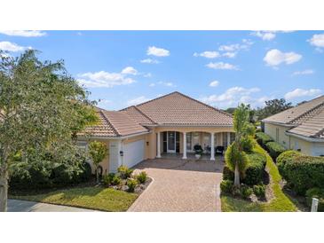 Attractive single-story home with a tile roof and landscaped front yard at 5521 Bilbao Pl, Sarasota, FL 34238