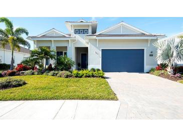 Front view of a lovely house with a blue garage door and well-manicured lawn at 8066 Redonda Loop, Bradenton, FL 34202