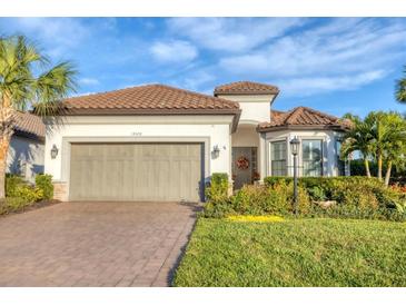 One-story home with tile roof, two-car garage, and landscaped front yard at 14608 Derna Ter, Bradenton, FL 34211