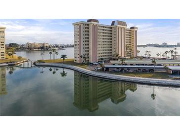 Aerial view of waterfront condo building with parking and water access at 4775 Cove Cir # 202, St Petersburg, FL 33708