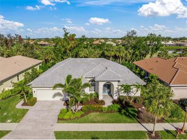 Single-Gathering home with gray roof, landscaping, and driveway, in a residential neighborhood at 557 Marsh Creek Rd, Venice, FL 34292