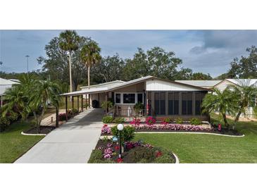 Single-story home with landscaped yard, covered porch and carport at 8520 Imperial Cir, Palmetto, FL 34221