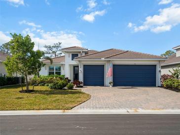 House exterior with two-car garage and landscaping at 116 Daylily Blvd, Nokomis, FL 34275