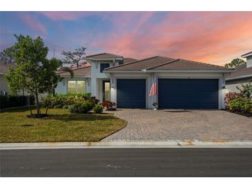 Inviting house exterior featuring a two-car garage and well-manicured lawn at 116 Daylily Blvd, Nokomis, FL 34275