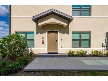 Tan building exterior with brown door and landscaping at 1944 Vista Landings Ct, Port Charlotte, FL 33953