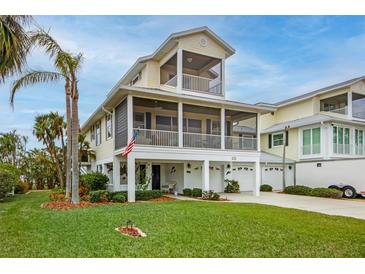 Two-story house with balcony, two-car garage, and manicured lawn at 220 82Nd St, Holmes Beach, FL 34217