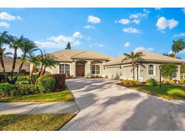 Single-story home with tile roof, two-car garage, and landscaped yard at 4941 Bridgehampton Blvd, Sarasota, FL 34238