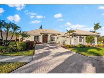 Single-story home with a tile roof, two-car garage, and landscaped yard at 4941 Bridgehampton Blvd, Sarasota, FL 34238