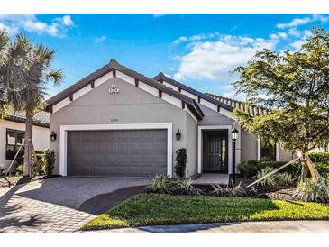 Single-story home with gray garage door and landscaping at 5255 Cicerone St, Sarasota, FL 34238