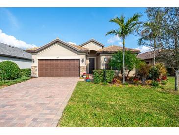 Attractive one-story home with brown garage door, landscaping, and paver driveway at 7409 Chester Trl, Bradenton, FL 34202