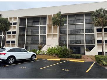 Condo building exterior with parking and landscaping at 6120 43Rd W St # 101B, Bradenton, FL 34210