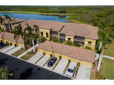 Aerial view of condo community showcasing building exterior, landscaping, and parking at 7315 River Hammock Dr # 206, Bradenton, FL 34212