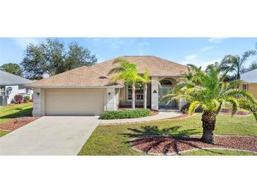 One-story home with a two-car garage and palm trees at 7518 Paspalum, Punta Gorda, FL 33955