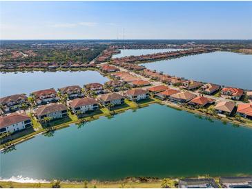 Stunning aerial view of lakeside homes with terracotta roofs in a well-maintained, planned community at 109 Porta Vecchio Bnd # 202, Nokomis, FL 34275