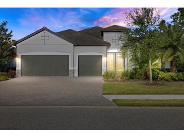 Two-story house with three-car garage, stone accents and landscaping at 12029 Perennial Pl, Bradenton, FL 34211