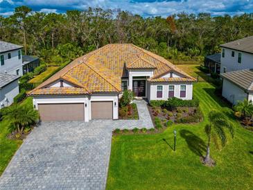 Aerial view of a single-Gathering home with a three-car garage and landscaped yard at 16219 Tradewind Ter, Bradenton, FL 34211