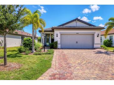 Single-story home with gray garage door and brick driveway at 17649 Northwood Pl, Bradenton, FL 34202