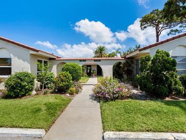 Neatly landscaped walkway to two-unit building with Spanish-style architecture at 2153 Pueblo Cir # V14, Sarasota, FL 34231