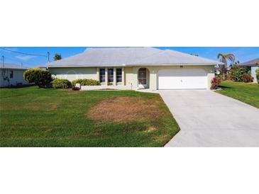 Charming single-story home featuring a well-maintained lawn and a two-car garage and beautifully manicured landscaping at 31 Bunker Pl, Rotonda West, FL 33947