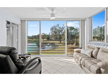 Bright sunroom with lake view and comfortable seating at 4440 Fairways Blvd # 206, Bradenton, FL 34209