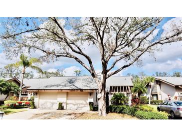 Charming home featuring a well-maintained yard and a two-car garage, complemented by a beautiful mature tree at 4629 Kingsmere # 20, Sarasota, FL 34235