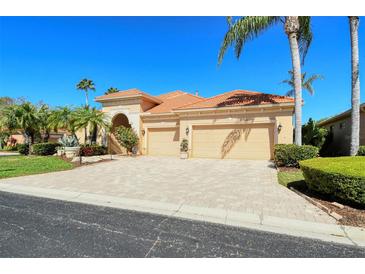 Two-story house with tile roof, three-car garage, and landscaped yard at 5118 Chateau Ct, Sarasota, FL 34238