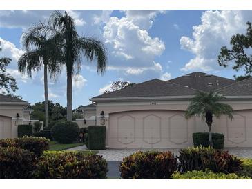 Tan villa with three-car garage and lush landscaping at 5449 Chanteclaire # 75, Sarasota, FL 34235