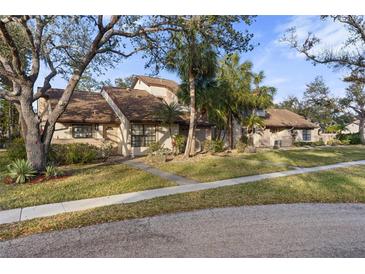 Charming home exterior with well-manicured lawn, mature trees, and a welcoming facade at 5616 Mashie Cir, North Port, FL 34287