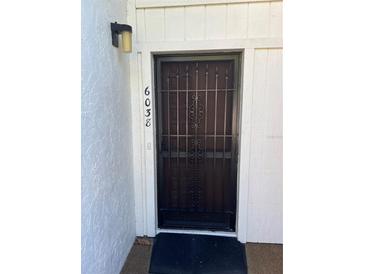 Exterior view of condo front door with security screen and address number at 6038 Red Maple Rd # 1003, Bradenton, FL 34210