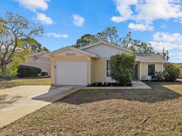 Bright yellow house with a white garage door and well-maintained lawn at 6507 36Th Avenue W Dr, Bradenton, FL 34209