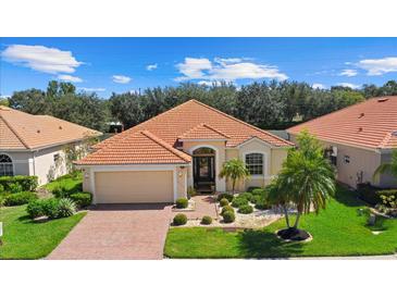 Attractive single-story home with a tile roof, landscaped yard, and brick paver driveway at 6841 74Th Street E Cir, Bradenton, FL 34203